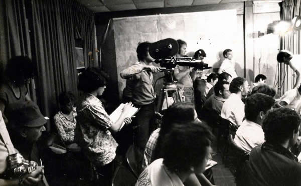 Brenda Martínez (de pie, con libreta en manos) con el equipo de la Comandancia General del Ejército en una conferencia de prensa del comandante Humberto Ortega. 1980. (Archivo de Brenda Martínez / INCINE). 